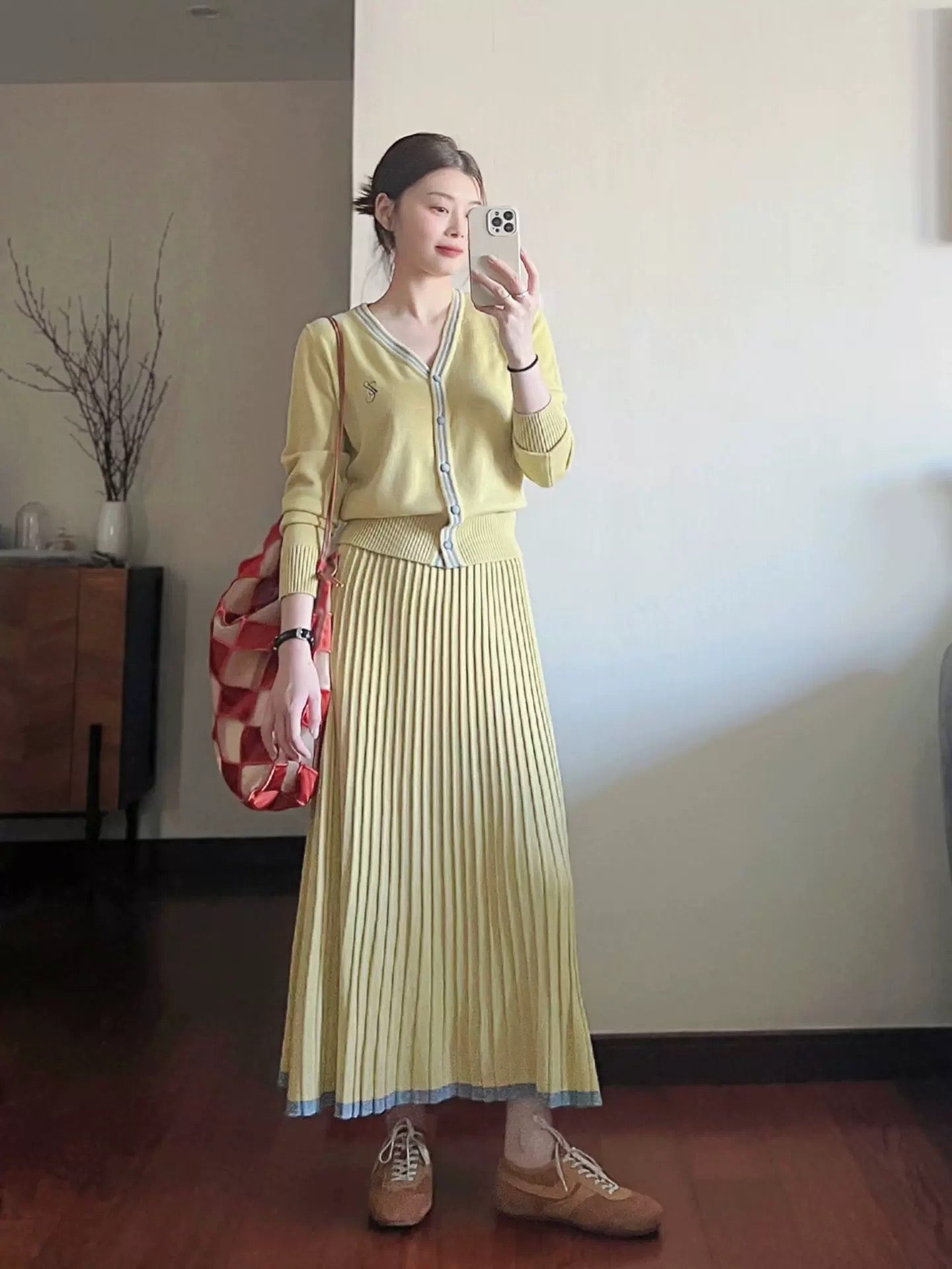 French-style yellow knitted cardigan, skirt, and dress two-piece set for women, a sophisticated and youthful autumn outfit.