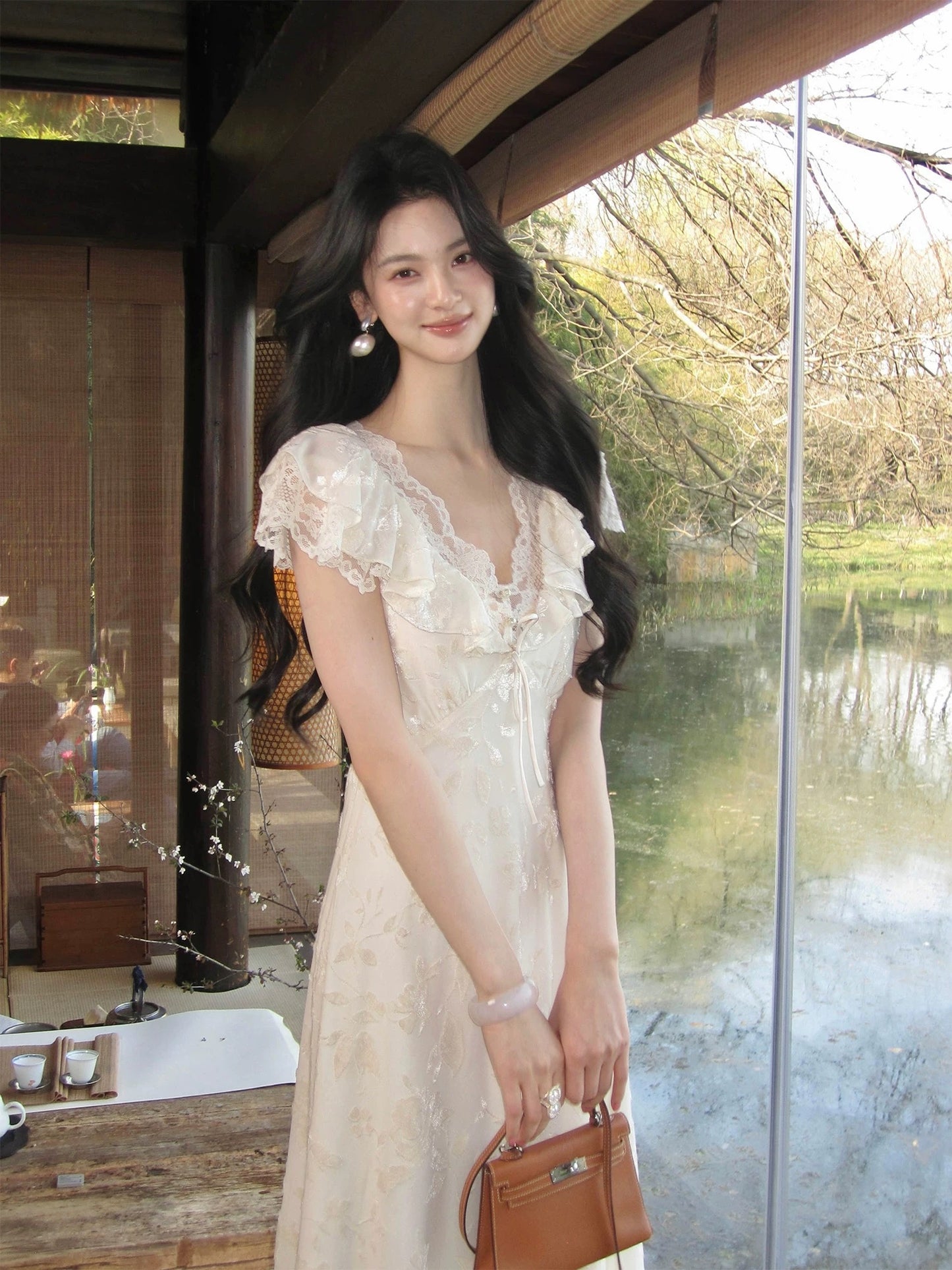 From a moment ago, a gentle, forest-inspired V-neck dress with textured lace and a fairy-like long skirt was created.