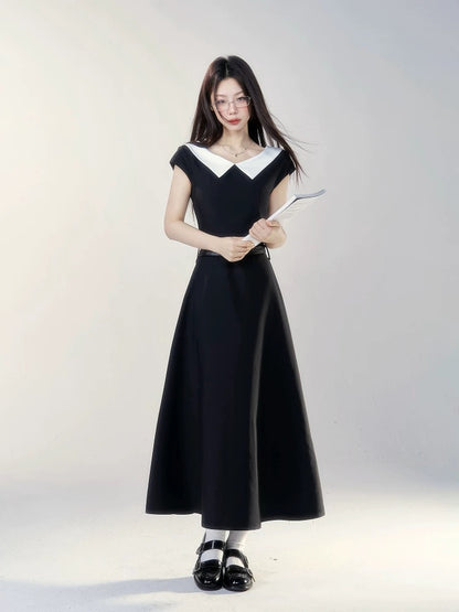 A black short-sleeved dress with a small wild berry design, a new summer style for 2026, featuring a flattering waist and a French-style long skirt.