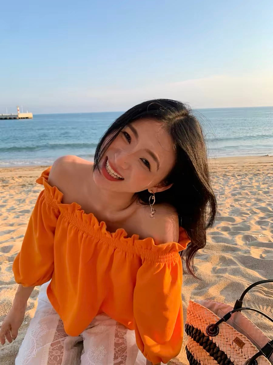 Unique, loose-fitting, off-shoulder top in orange—a stylish, niche design with three-quarter sleeves, perfect for petite frames (New Spring/Summer 2026 Collection).