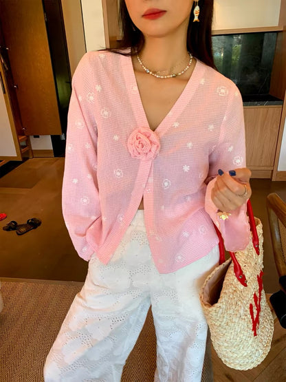 Distinctive and refined: a chic, Korean-style blouse featuring pink embroidery and a V-neck—a new long-sleeved top for 2026.