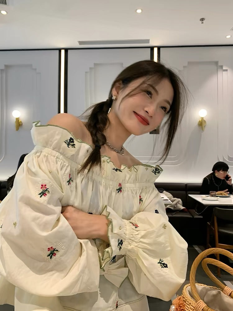 Relaxed-fit, distinctive off-shoulder blouse featuring embroidery and a unique design—a standout piece from the 2026 Spring/Summer collection.