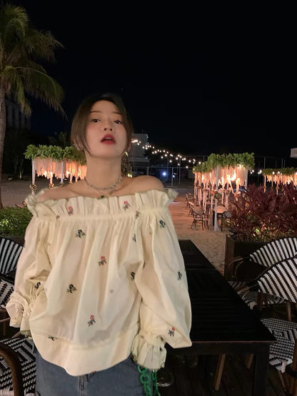 Relaxed-fit, distinctive off-shoulder blouse featuring embroidery and a unique design—a standout piece from the 2026 Spring/Summer collection.