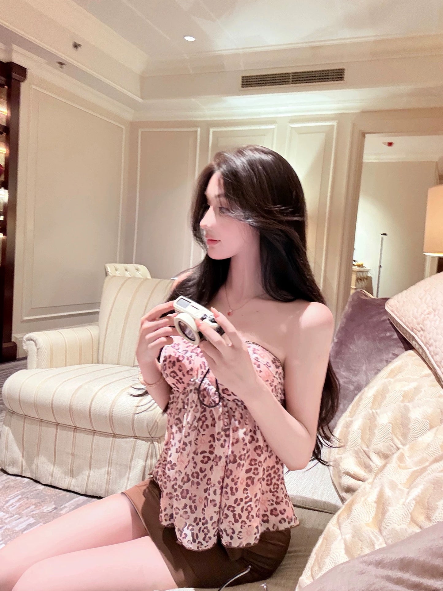 WW Original: A sexy two-piece set featuring a pink-toned, retro-style leopard print camisole and a high-waisted, brown, form-fitting mini skirt.