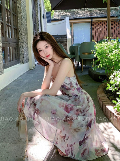A stunning, French-style romantic dress featuring a dreamy blended print, a sleeveless strapless bodice, and a waist-cinching, slimming fit—perfect for a chic vacation look and highly photogenic.