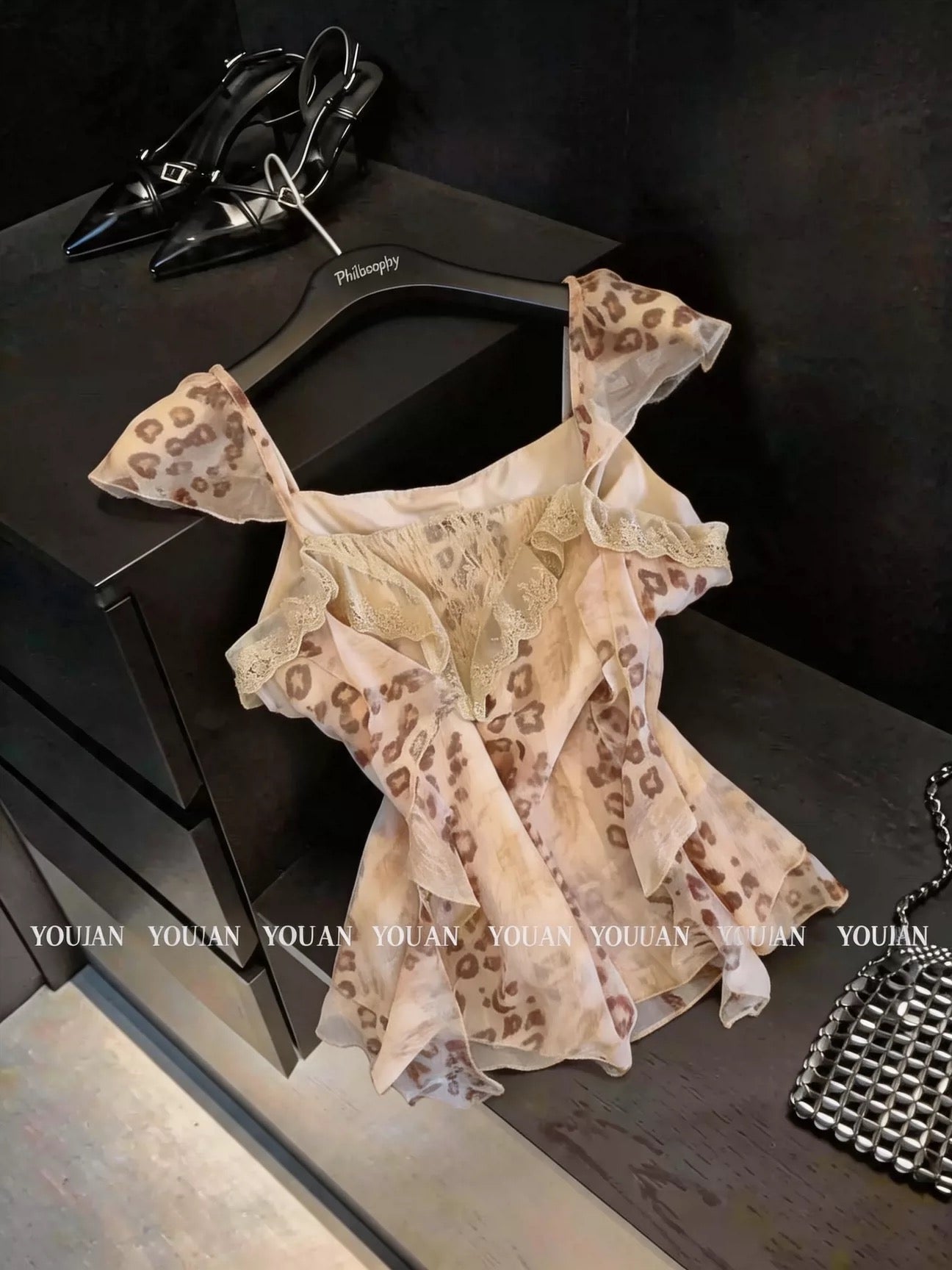 French vintage-style leopard print chiffon top featuring flutter sleeves, spaghetti straps, lace paneling, ruffles, and ribbon ties.