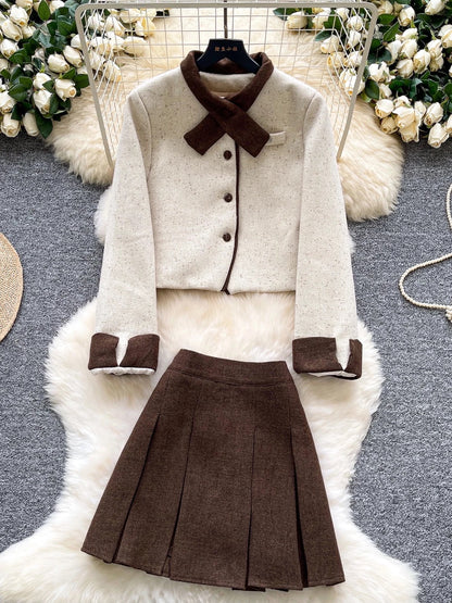 Elegant and sophisticated women's autumn/winter outfit: Short-sleeved long-sleeved jacket with a bow collar paired with a high-waisted pleated skirt.