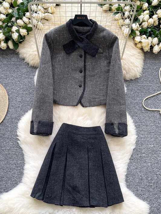 Elegant and sophisticated women's autumn/winter outfit: Short-sleeved long-sleeved jacket with a bow collar paired with a high-waisted pleated skirt.