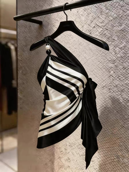 Chic, high-end, and stylish: a youthful black-and-white striped top featuring an asymmetrical design and distinctive camisole detailing—perfect for summer.