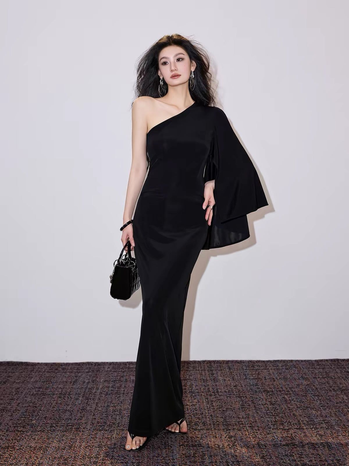 Exclusively tailored, sophisticated French-style one-shoulder draped-sleeve dress; a form-fitting, waist-cinching gown designed to flatter the figure.