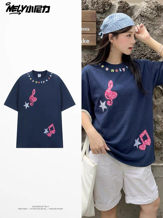 Unisex loose-fit short-sleeve T-shirt featuring a musical note and star appliqué; a versatile, casual crew-neck top with a unique, distinctive design.