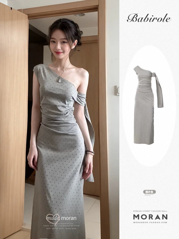 Sophisticated grey off-shoulder dress with a unique, minimalist design; a new summer 2025 style; fitted waist and elegant long dress.