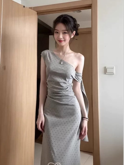 Sophisticated grey off-shoulder dress with a unique, minimalist design; a new summer 2025 style; fitted waist and elegant long dress.
