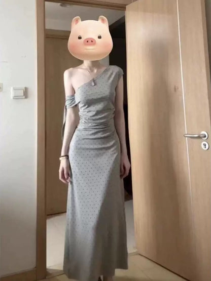Sophisticated grey off-shoulder dress with a unique, minimalist design; a new summer 2025 style; fitted waist and elegant long dress.