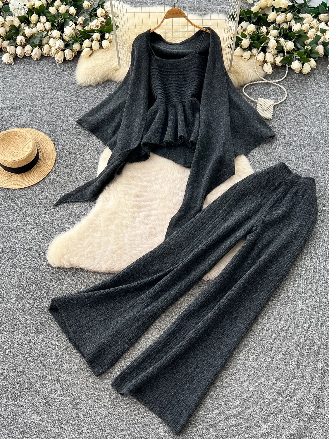 Gentle outfit for women: a three-piece suit with a waist-hugging camisole, a loose sweater, and high-waisted wide-leg pants.