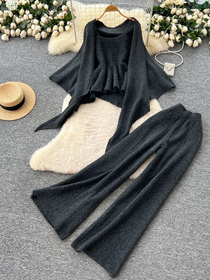 Gentle outfit for women: a three-piece suit with a waist-hugging camisole, a loose sweater, and high-waisted wide-leg pants.
