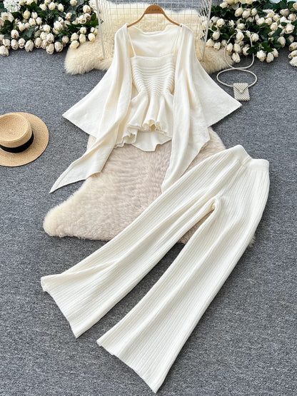 Gentle outfit for women: a three-piece suit with a waist-hugging camisole, a loose sweater, and high-waisted wide-leg pants.