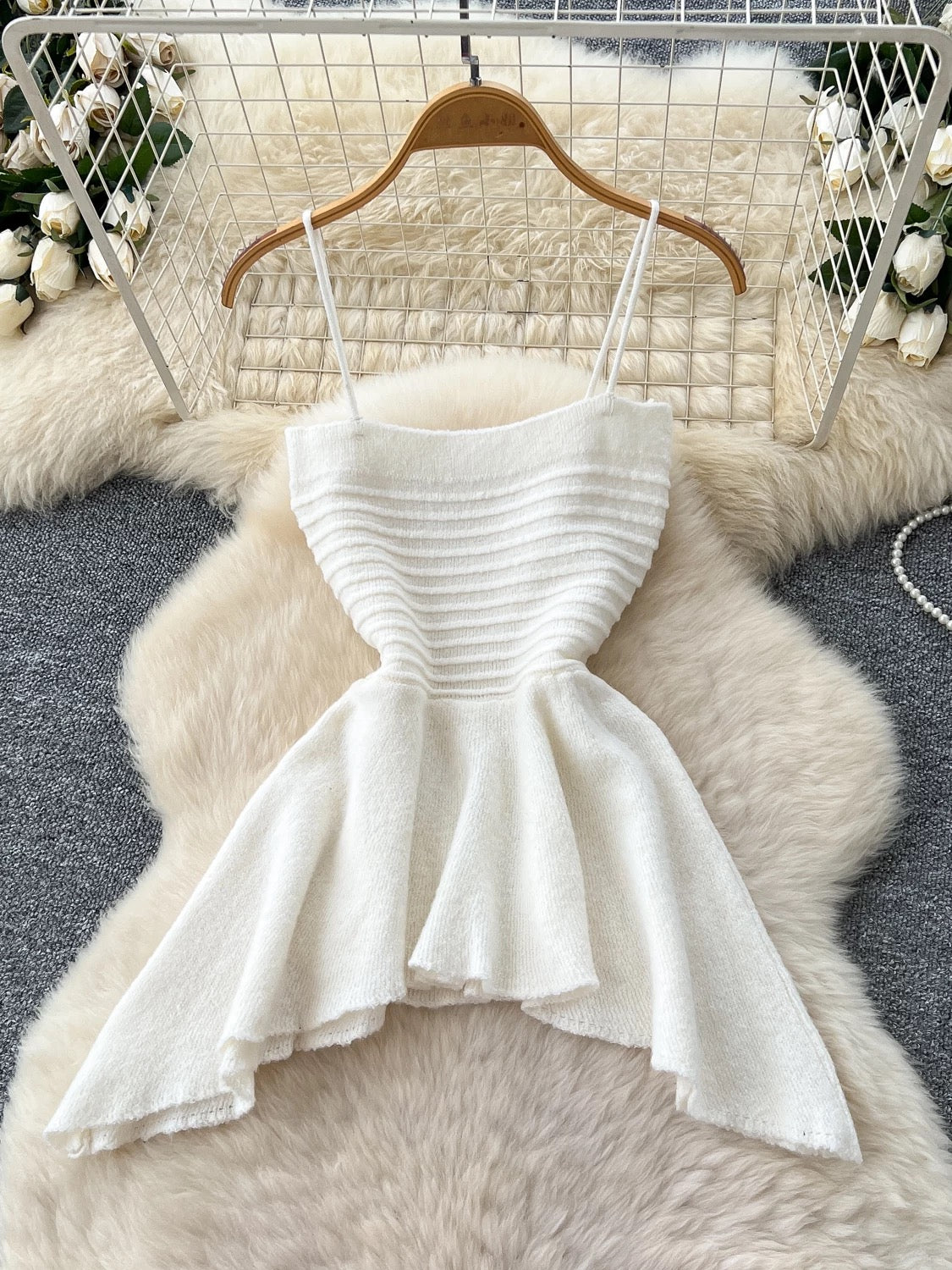 Gentle outfit for women: a three-piece suit with a waist-hugging camisole, a loose sweater, and high-waisted wide-leg pants.