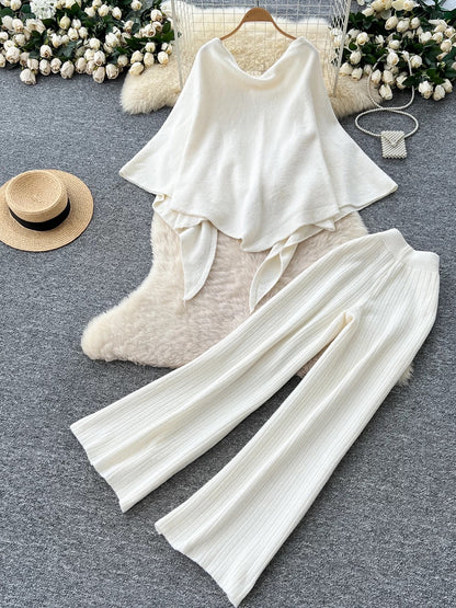 Gentle outfit for women: a three-piece suit with a waist-hugging camisole, a loose sweater, and high-waisted wide-leg pants.