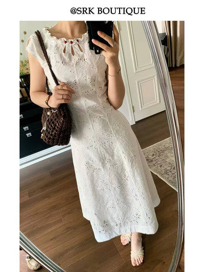 SRK French-style sleeveless A-line maxi dress in white, featuring intricate embroidery, a waist-cinching silhouette, and a minimalist, elegant aesthetic.