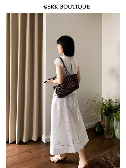 SRK French-style sleeveless A-line maxi dress in white, featuring intricate embroidery, a waist-cinching silhouette, and a minimalist, elegant aesthetic.