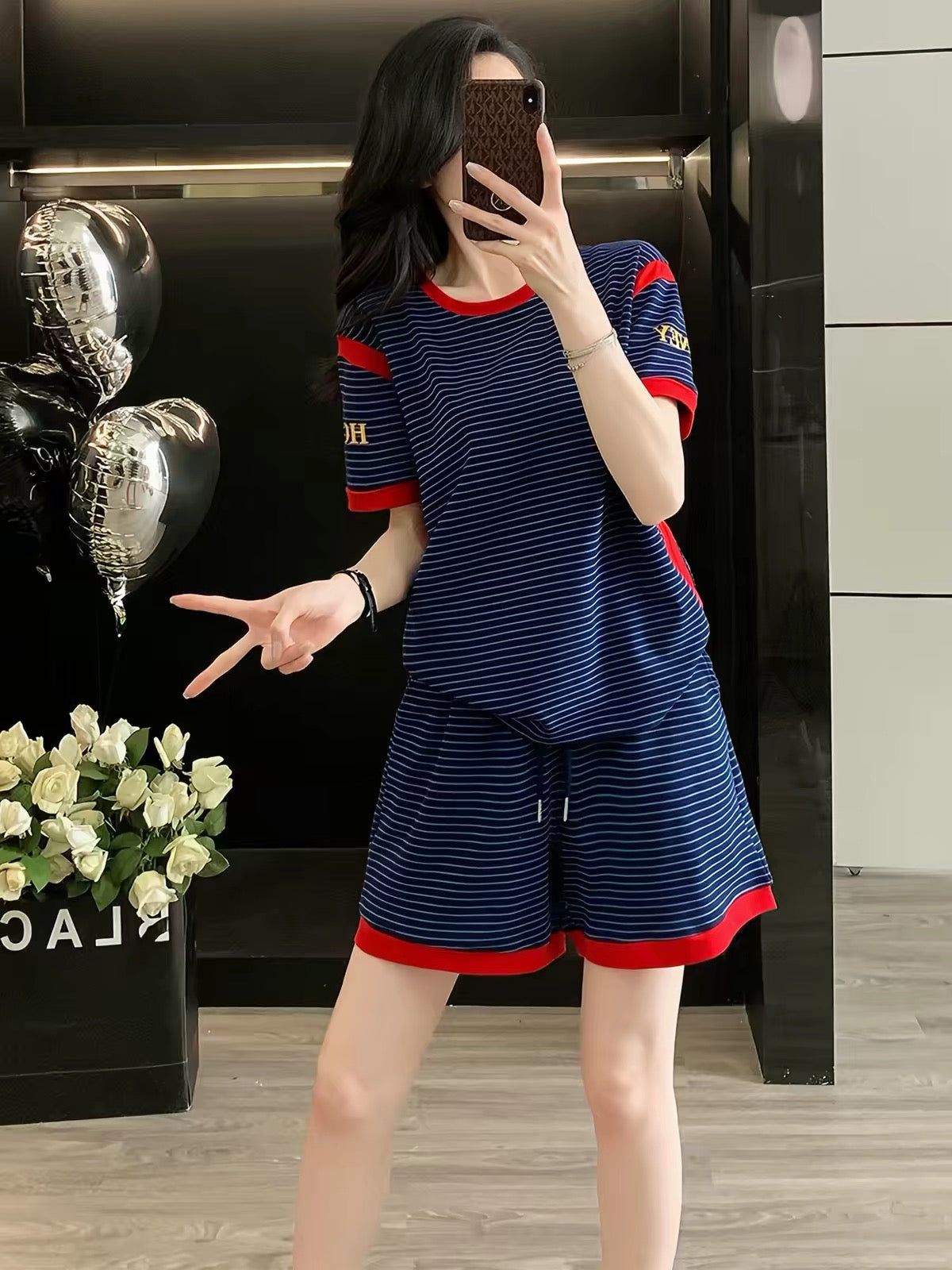 Stylish, trendy, and youthful women's summer two-piece set featuring a striped short-sleeve top and shorts—a loose, casual, and sporty outfit perfect for fitness and running.