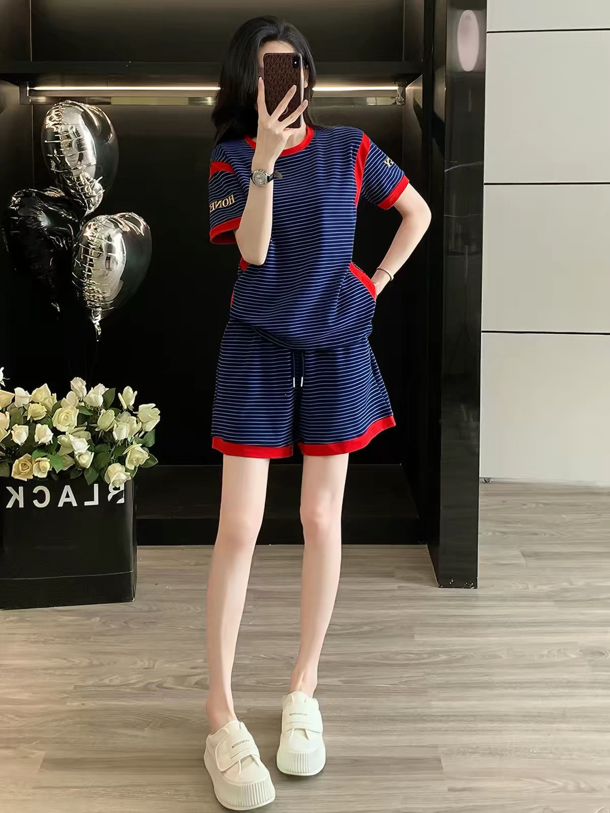 Stylish, trendy, and youthful women's summer two-piece set featuring a striped short-sleeve top and shorts—a loose, casual, and sporty outfit perfect for fitness and running.