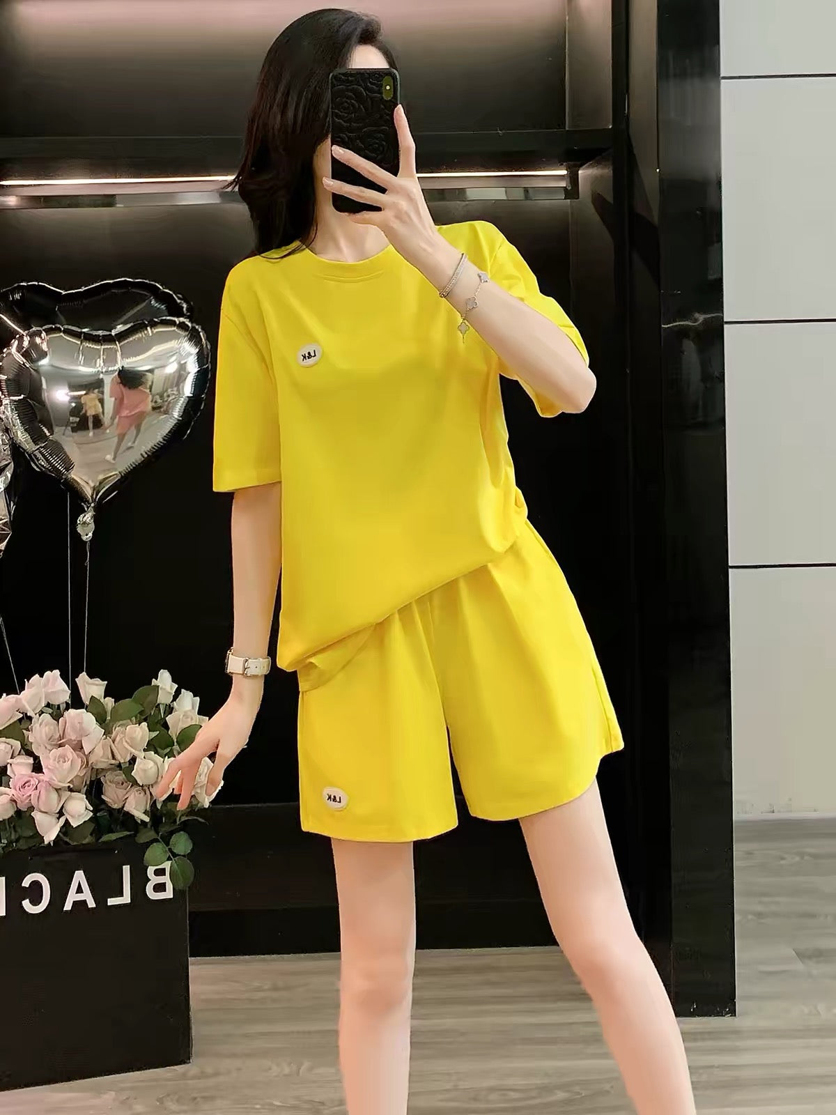 Stylish, youthful-looking women's summer 2026 two-piece set featuring a round-neck short-sleeve top and shorts; a loose, trendy, and slimming casual-sporty outfit.