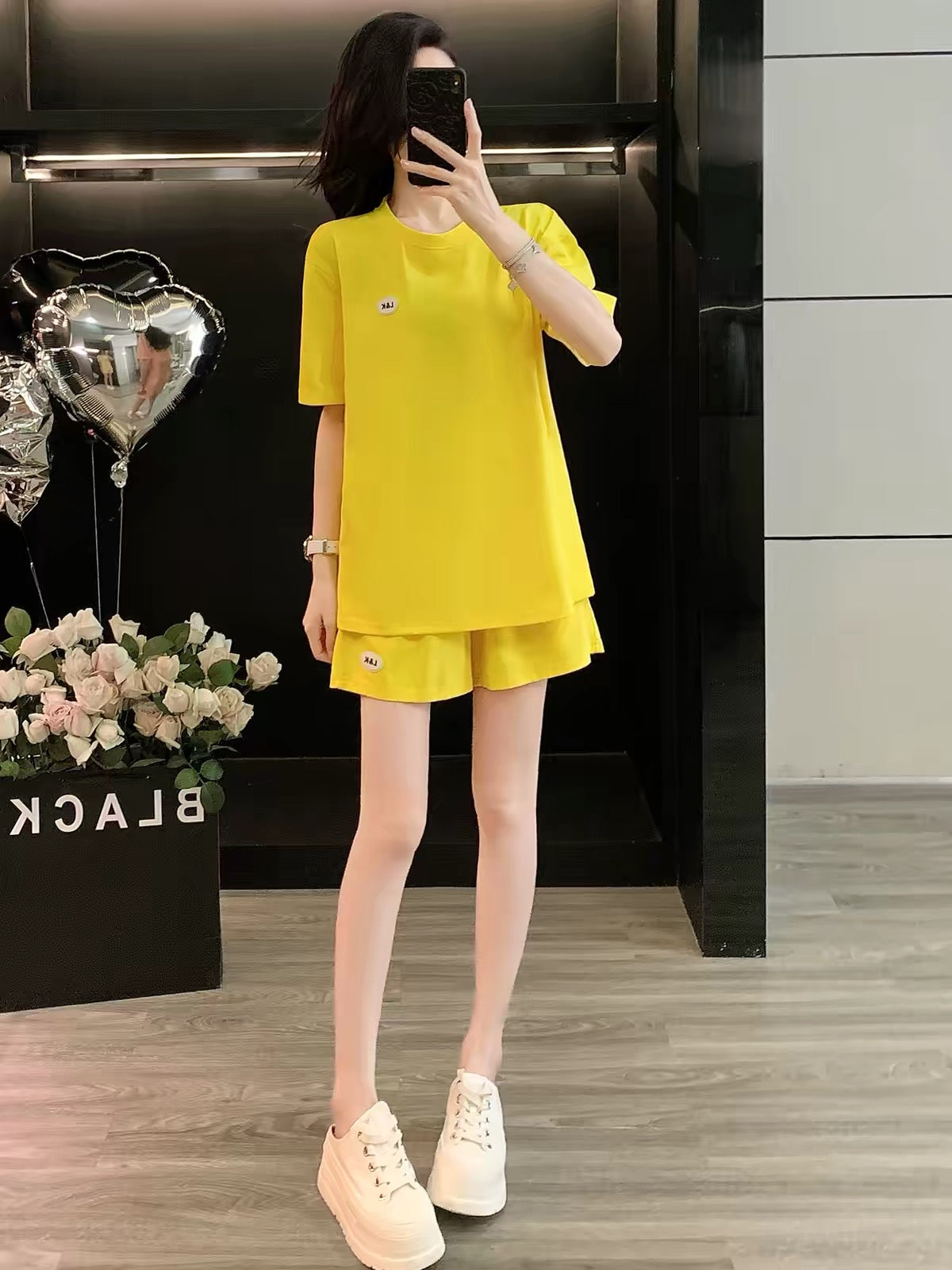 Stylish, youthful-looking women's summer 2026 two-piece set featuring a round-neck short-sleeve top and shorts; a loose, trendy, and slimming casual-sporty outfit.