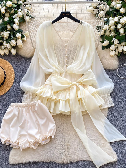 A fairy-tale style, unique design featuring a bow tie, cinched waist, lace trim, long sleeves, ruffles, and mesh. Shorts are also available.